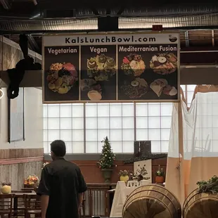 a man standing in front of a display of vegetables