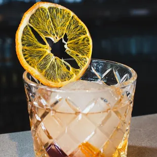 an orange slice on the rim of a cocktail glass