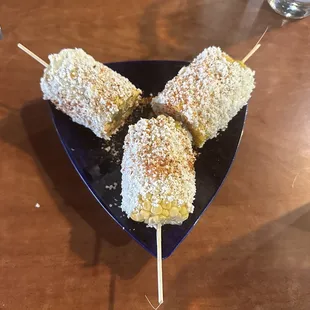 a plate of corn on a stick