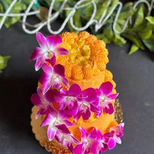 Small tiered cake - white cake with mango filling and mango buttercream, decorated with edible orchids