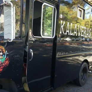 a black food truck parked on the side of the road