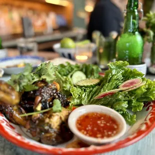 gai yaang naa por charcoal grilled half chicken glazed with coconut cream, dark soy and fish sauce, served with sticky rice and crudité