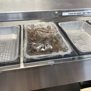 three trays of food on a conveyor belt