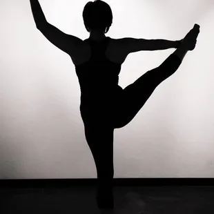a silhouette of a woman doing a yoga pose