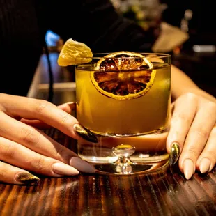 a woman holding a glass of cocktail