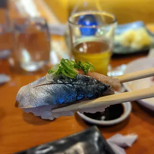 a close up of a piece of sushi with chopsticks