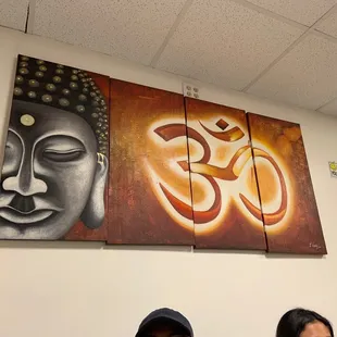 two people sitting in front of a painting