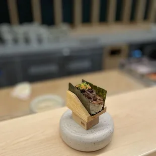 a sushi sandwich on a stone