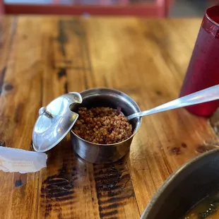 a bowl of ramen and a spoon on a wooden table