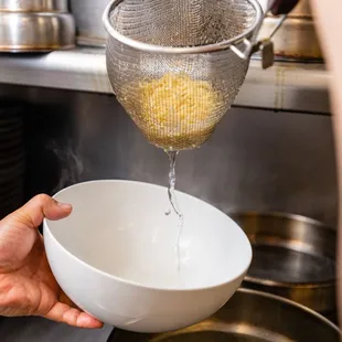 a person pouring water into a bowl