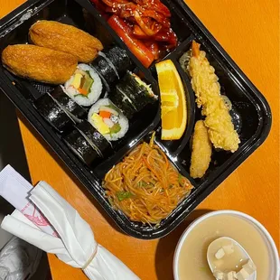 This bento is packed: Jjolmyun, Tteokbokki, Kimbap, Yeobochubap, Shrimp Tempura, Gimari, Miso Soup, and a Jalapeño Popper