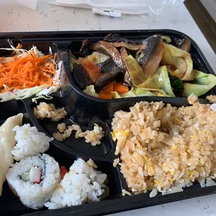 a tray of rice, vegetables, and meat