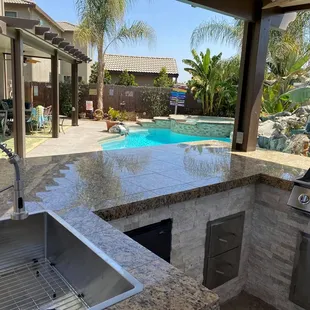an outdoor kitchen with a grill and sink