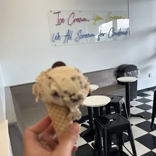 a hand holding an ice cream cone