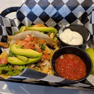 a tray of tacos and salsa