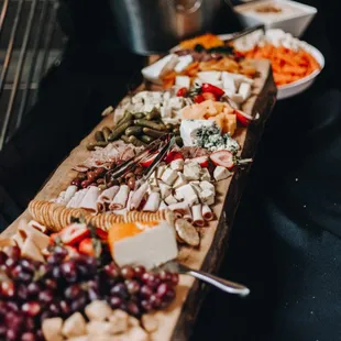 a variety of cheeses and meats on a wooden board