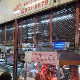 a woman standing in front of a display of meat