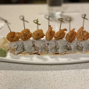 a sushi roll with shrimp on top