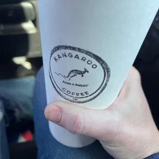 a hand holding a cup of coffee