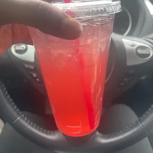 a hand holding a plastic cup with a straw