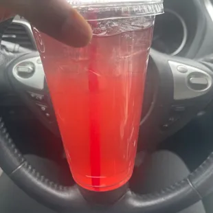 a hand holding a plastic cup with a straw