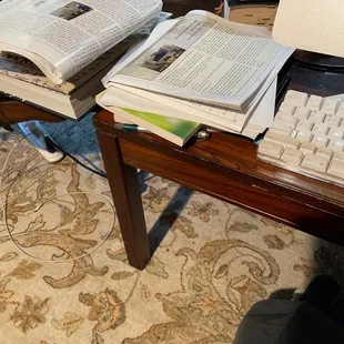 a desk with a computer, keyboard, and books