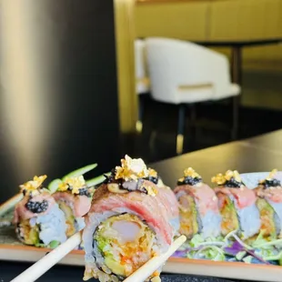a close up of a roll with chopsticks