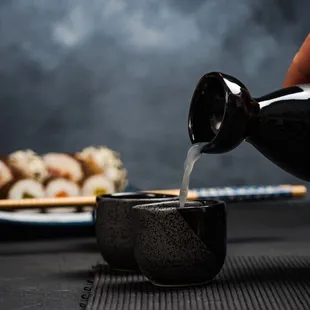 a person pouring sake into a bowl