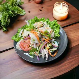 Thai seafood salad, mussels, squids, shrimps and fish fillets, onions, tomatoes, carrots mixed in spicy chili lime juice.
