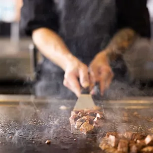 a person cooking food on a grill