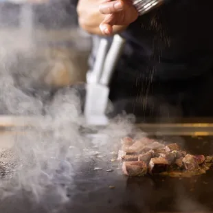 a person cooking food on a grill