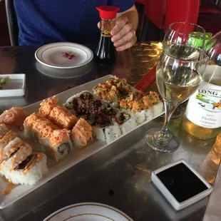 a plate of sushi and a glass of wine