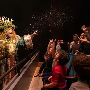 Matthew Rapport dazzles children sitting in the Glitter Row as Ghost of Christmas Present in KCRep's 2019 production of A CHRISTMAS CAROL.