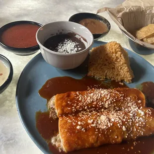 Keep enchiladas with a wonderful enchilada sauce, black beans, and Mexican rice