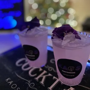 two cocktails with ice and purple flowers