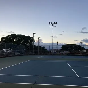 Tennis courts with huge cracks overlooking the basketball courts and the pool