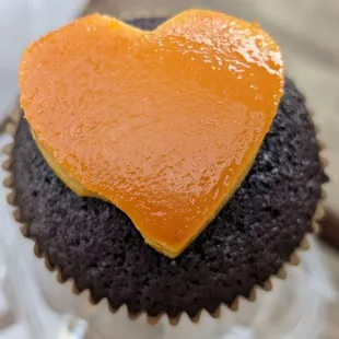 Ube cupcake with leche flan heart on top. Looks as of a little part came off before it was packed.