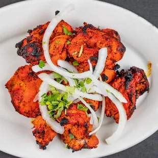 a plate of chicken wings and onions