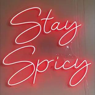a neon sign that says stay spiciy