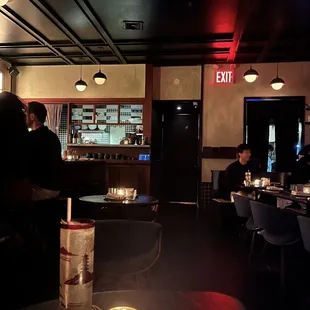 people sitting at tables in a dimly lit restaurant