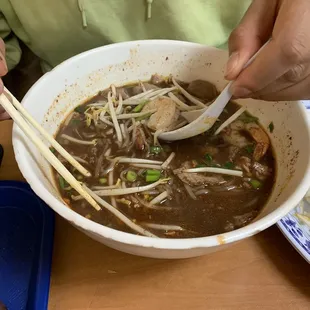 a bowl of soup with chopsticks