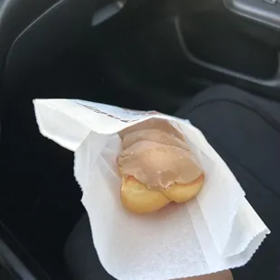 a person holding a donut in a wrapper