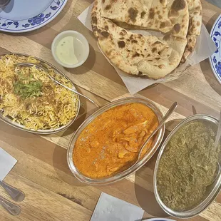 Left to right: Chicken Biryani ($13.99), Butter Chicken ($12.99), Aaloo Palak ($11.99) Top: Plain Naan ($2.99 each)