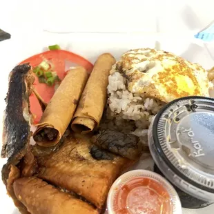 a plate of food that includes eggs, sausages, rice, and other foods