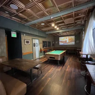 Back room with large screen and pool table