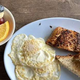 Extra crispy salmon with eggs, wheat toast and fruit