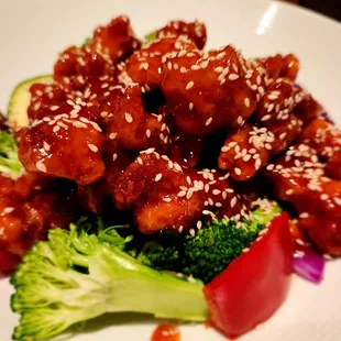 a plate of food with broccoli and sesame seeds