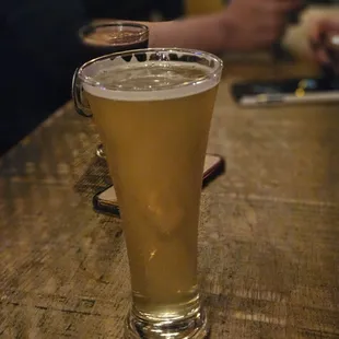 a glass of beer on a bar