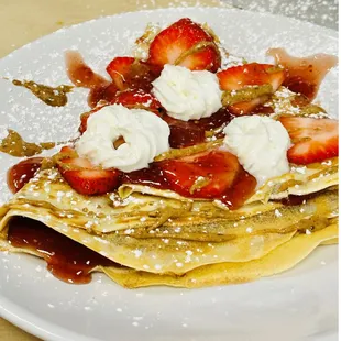 a crepe with strawberries and whipped cream