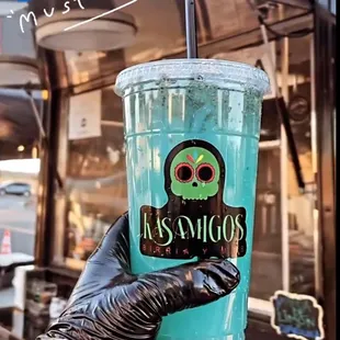 a hand holding a blue ocean drink
